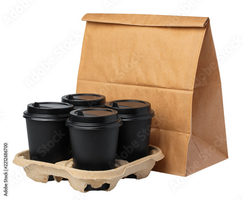 Coffee cups in a cardboard tray next to a brown paper bag for takeout