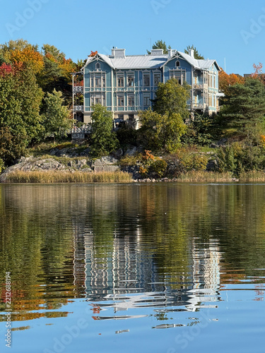 Peaceful Autumn Lake Landscape with Forest and blue villa