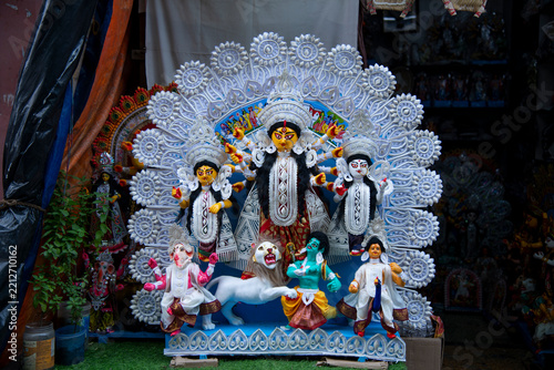 An ornate idol of Hindu Goddess Durga along with Lakshmi, Saraswati, Ganesha, and Kartikeya, decorated with elaborate traditional white sholapith craft background (Daker Saaj)