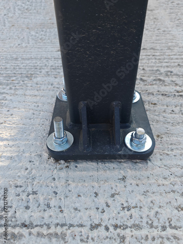 Post and Base Plate mounted on the concrete foundation secured with a threaded anchor bolts, washers, and nuts