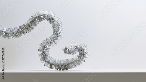 Cozy floating silver tinsel twisting in mid-air, festive photo