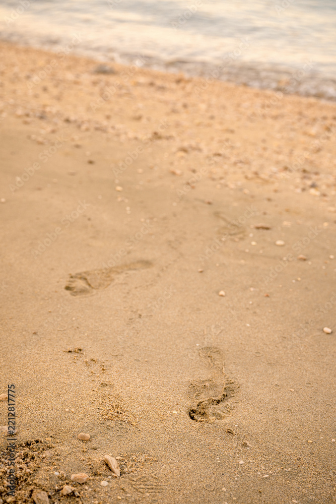 Obraz premium Footprints on a sandy shoreline in Kvarner Bay, Croatia. Concept of travel, summer vacations, freedom, and taking steps forward.
