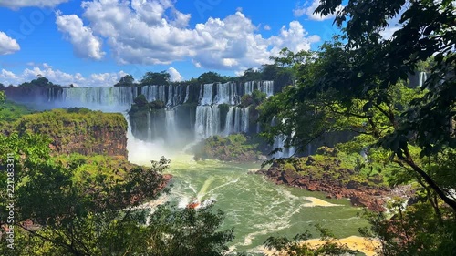 Iguazu Falls, Argentina, panoramic footage of massive waterfalls, lush jungle, and tourist boat in motion