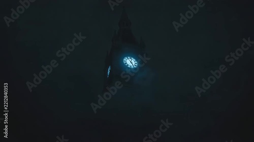 Clock tower silhouetted against dramatic stormy night sky with flashing lightning bolts and thick billowing dark clouds
