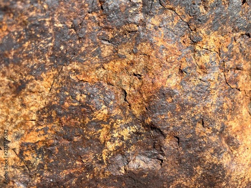 Close-up of weathered brown and rusty rock texture with rough uneven surface