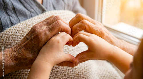 Elderly and Child Hands Forming Heart Shape Together