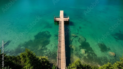 Wooden pier extending into vivid emerald green alpine lake water