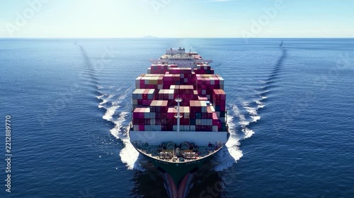 Front view tracking of a heavy loaded super container cargo ship traveling with speed over the ocean