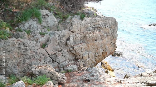 Rugged limestone rock formation overlooking the clear blue water of the Mediterranean coastline