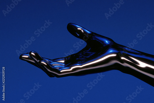 Metallic Hand Reaching Forward on Blue Background