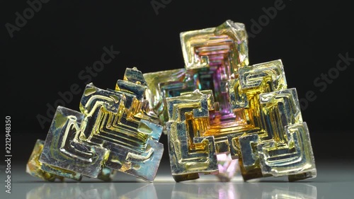 Colorful bismuth crystals display stepped growth patterns and iridescent oxide layers formed by surface oxidation, illustrating distinctive properties of this metallic element