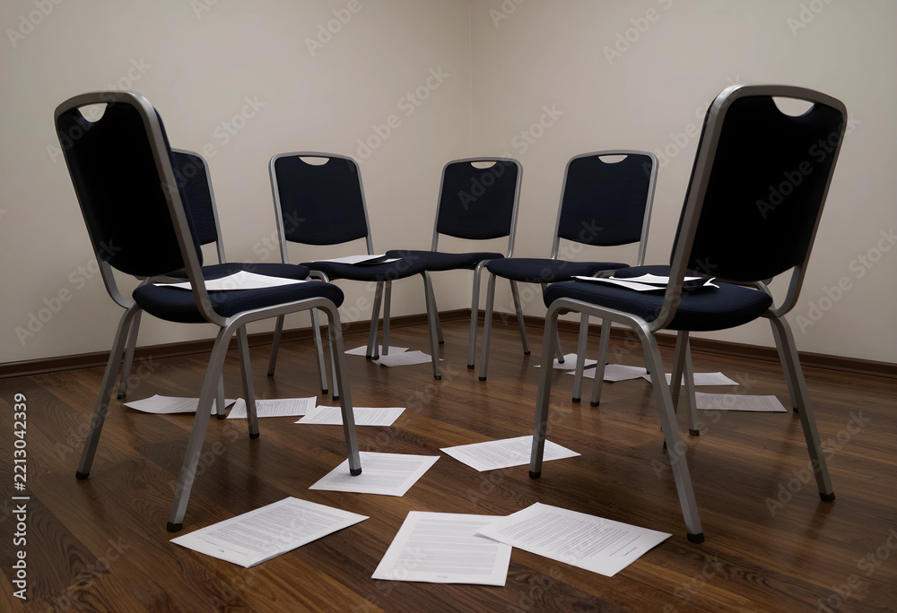 Obraz premium Layoffs and corporate downsizing, empty office chairs in a circle with scattered documents on the floor job loss and unemployment crisis