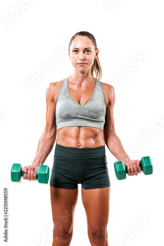 Female fitness enthusiast lifting green dumbbells in gym attire emphasizing strength and health