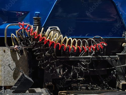 Detail of pneumatic hoses at the rear of a semi-truck tractor.