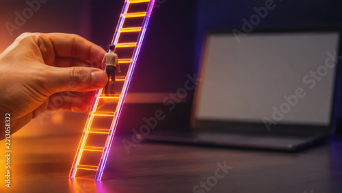 Neon achievement ladder concept with miniature person climbing toward opportunity beside laptop screen in dark workspace
