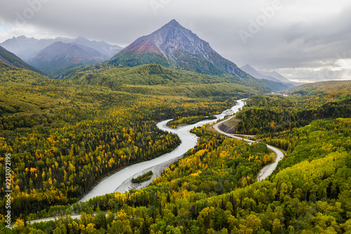 river and mountain road in the autumn with pyramid-shape mountain in background