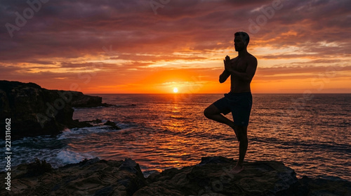 Man Meditating in Tree Pose on Ocean Cliff at Sunset Serene Seaside Wellness