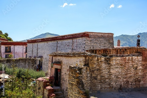 Ruins of former halls destroyed during the Cultural Revolution on the hilltop of Ganden Monastery in Dagze, Tibet, with weathered stone walls and mountain scenery