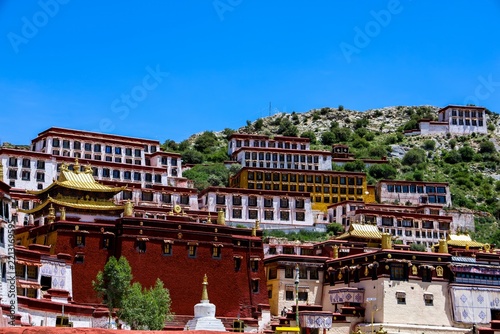 Ganden Monastery main buildings in Dagze, Tibet, a Tibetan Buddhist hillside complex rebuilt after the Cultural Revolution, with red and white walls and golden roofs, July 2025.