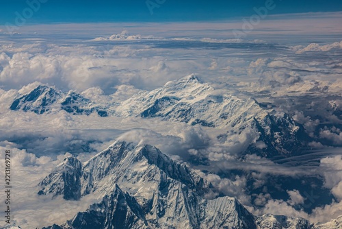 Aerial view of the Eastern Himalayas near Nyingtri, Tibet, showcasing rugged snow-capped mountains, dramatic peaks, glaciers, and expansive high-altitude landscapes