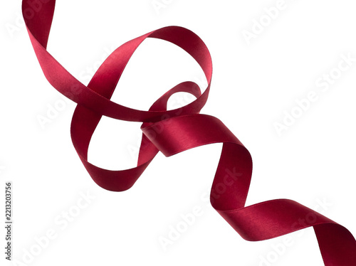 Elegant flowing dark red silk ribbon isolated on a solid black background for festive holiday design