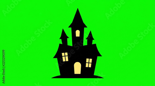 Black silhouette of a spooky haunted castle with glowing windows on green screen for Halloween or horror design
