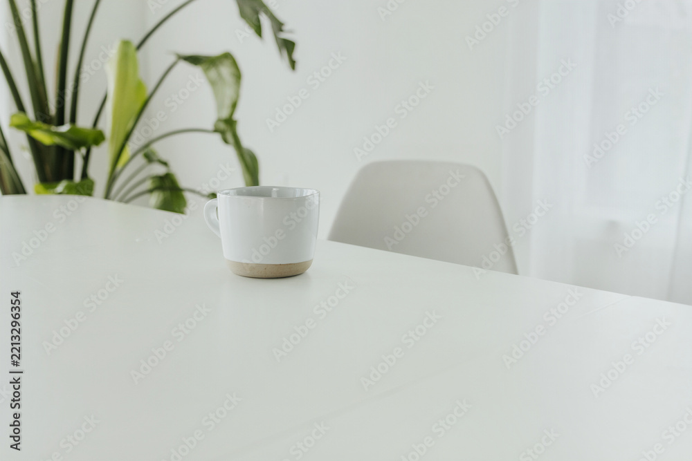 Fototapeta premium Minimalist scene of a coffee cup on a white table