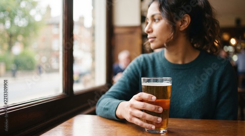 Enjoying a moment of reflection with a cold drink by the window at a cozy pub Generative AI