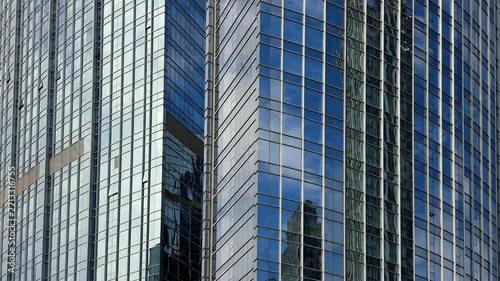 A close-up view of modern skyscrapers featuring reflective glass facades and metallic structural details in an urban setting.