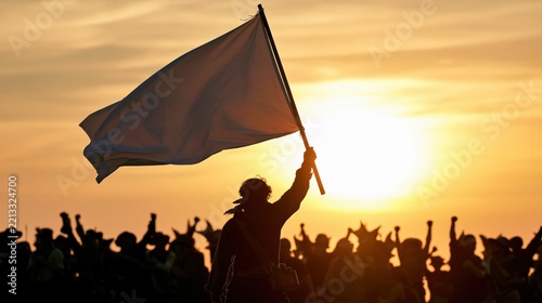 A person holds a white flag aloft amidst a cheering crowd at sunset.
