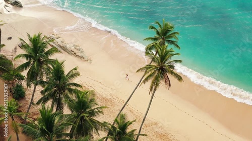 Woman Walking on a Tropical Sandy Beach with Palm Trees Overhead View
