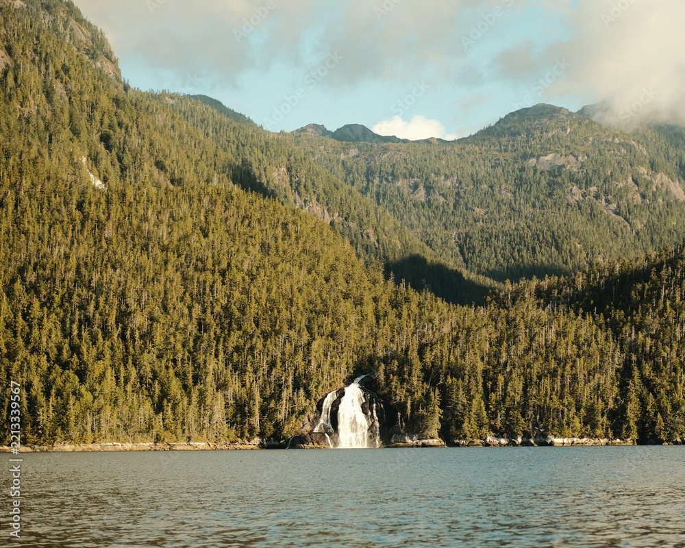 Fototapeta premium Green mountain valley with a waterfall in a fjord landscape