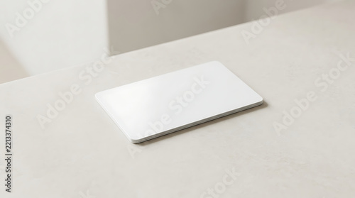 A blank white rectangular business card resting on a smooth light grey surface with soft natural lighting and a clean minimalist composition isolated on a transparent background