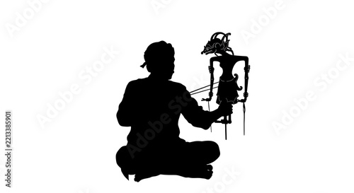 Indonesian puppeteer silhouette performing wayang shadow puppet show