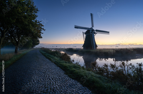 A traditional windmill during a tranquil, autumn dawn in the Dutch countryside. Krimstermolen, Zuidwolde.