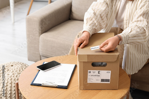 Obraz na plátně E-commerce return policy and customer service, person preparing a parcel with a