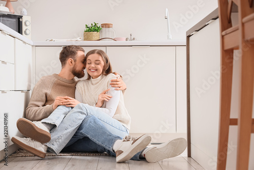 Happy young couple sitting in kitchen on winter day