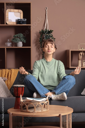 Mindfulness and mental health, young woman meditating in lotus position on so...