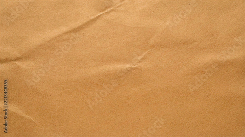 Close-up textured background of crumpled brown paper with subtle shadows
