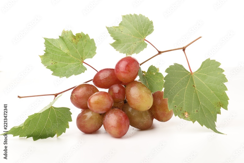 Fototapeta premium Bunch of fresh ripe grapes with green leaves on white background