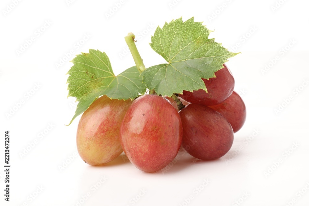 Fototapeta premium Bunch of fresh ripe grapes with green leaves on white background