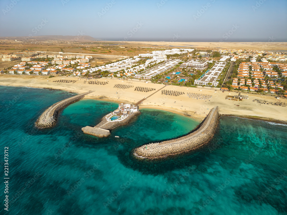 Fototapeta premium Aerial view of beachfront resort complex with breakwaters on Sal, Cape Verde