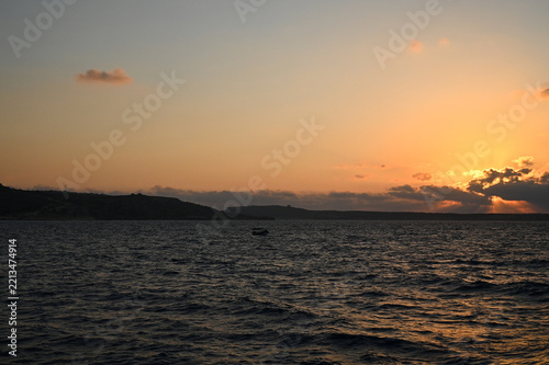 Un petit bateau dans la mer au coucher de soleil à Malte