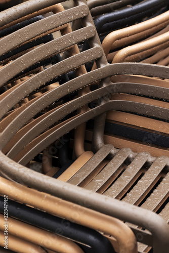 Rain-Soaked Stacked Chairs at an Outdoor Cafe in Late Autumn. Close-up.