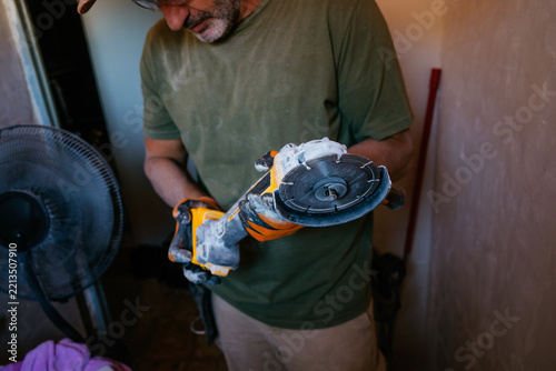Man holding angle grinder during home renovation work