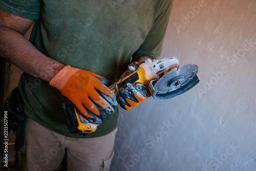 Construction worker using angle grinder for renovation work
