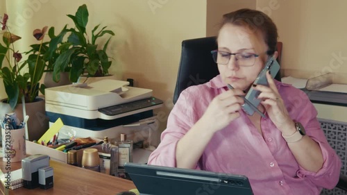Busy Businesswoman Multitasking with Phone and Laptop in Office