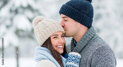Couple sharing a tender moment in a snowy winter landscape, symbolizing romance, warmth, and shared joy during the cold season