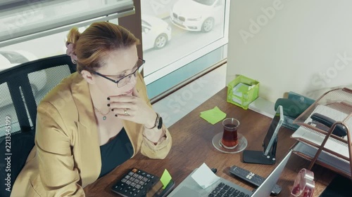 Focused Businesswoman Using Calculator at Office Desk