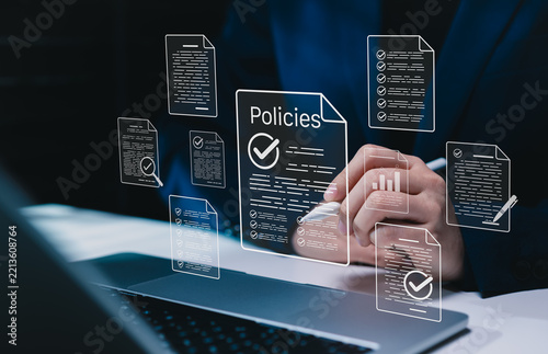 Policy documentation and compliance concept. Businesswoman reviews digital document Policies with icons, checklists, certifications, and financial detail. policy management, regulatory compliance,